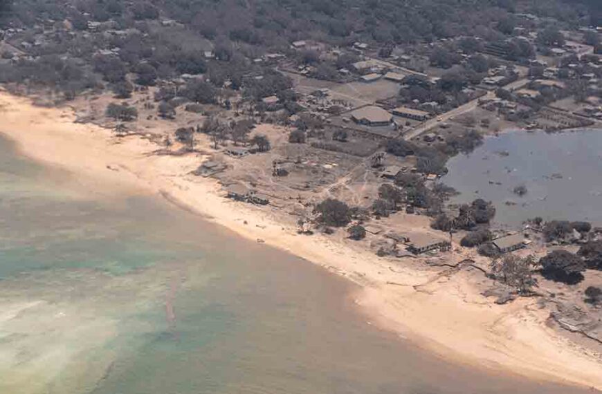 An aerial view of the ash covering a village by the beach in Tonga.