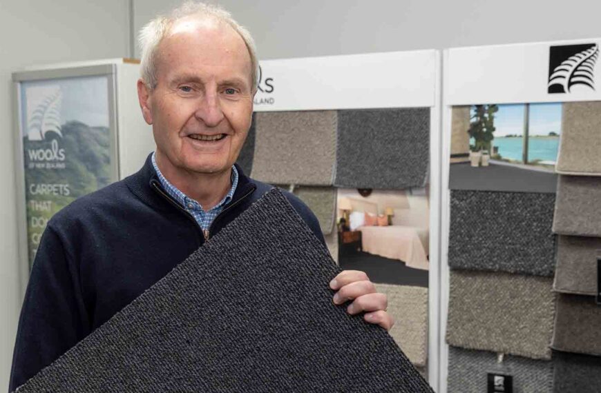 John McWhirter holds a wool carpet tile.