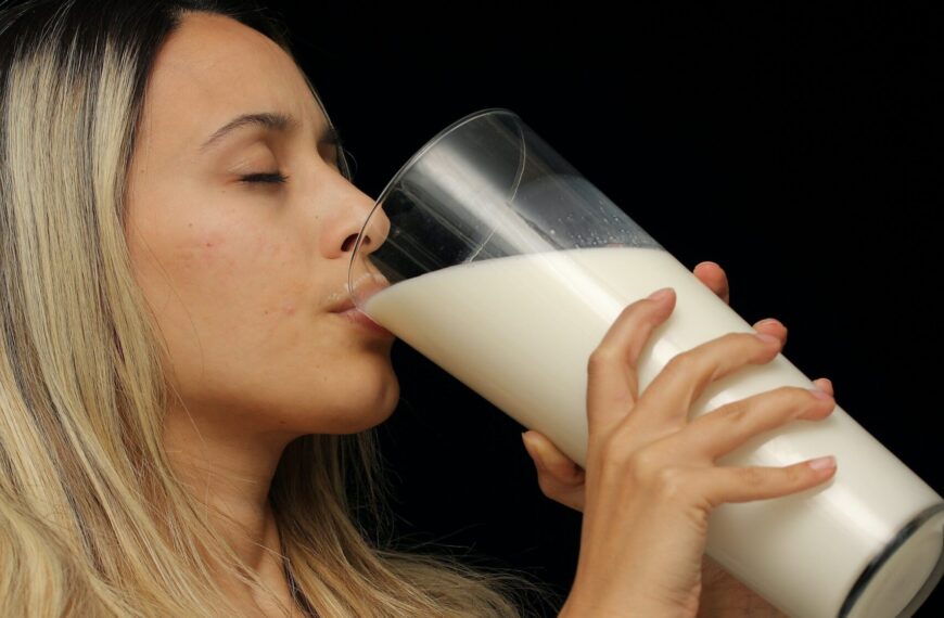 woman drinking a tall glass of milk